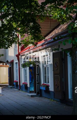 Une photo verticale de magasin sur une rue latérale à Tallinn avec un toit rouge et décoré de boîtes à fleurs. Banque D'Images