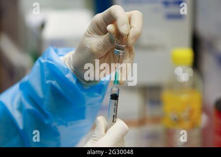 Nonthaburi, Thaïlande. 13 juin 2021. Un travailleur de la santé prépare une dose du vaccin CoronaVac avant de vacciner les gens dans un centre de vaccination de la province de Nonthaburi, En périphérie de Bangkok, la plupart des gens pensent que la distribution et l'allocation des vaccins contre Covid-19 dans le pays ont été politiquement mêlés au manque de confiance dans la gestion par le gouvernement de la situation de Covid-19, selon une enquête de l'Institut national de l'Administration du développement, ou Nida Poll. Crédit : SOPA Images Limited/Alamy Live News Banque D'Images