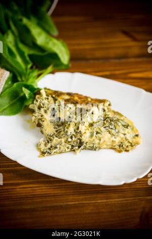 omelette aux œufs frits avec sorrel à l'intérieur, sur une table en bois. Banque D'Images