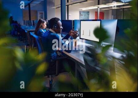 Deux directeurs travaillent dans le bureau de nuit, vue arrière Banque D'Images