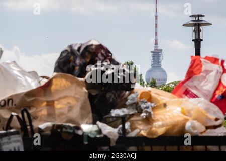 Berlin, Allemagne. 13 juin 2021. La tour de télévision de Berlin sort de derrière une poubelle pleine dans Volkspark Friedrichshain. Dans plusieurs parcs de Berlin, de grands groupes ont appelé la police la nuit jusqu'au samedi. En outre, en raison de violations des règlements d'hygiène dans la pandémie, la police a dégagé des espaces verts, a annoncé l'autorité samedi. Credit: Christoph Soeder/dpa/Alay Live News Banque D'Images