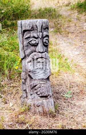 Idole de bois dieu slave par un chemin dans la forêt. Forêt en arrière-plan. Banque D'Images