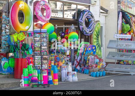 Jouets de plage, cartes postales et journaux à vendre à l'extérieur d'une boutique en bord de mer à Lyme Regis, Jurassic Coast, Dorset, Angleterre Banque D'Images