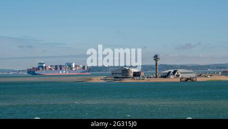 Southampton, Angleterre, Royaume-Uni. 2021. Vue sur le paysage de Calshot, château, tour de garde-côtes et centre sportif avec un porte-conteneurs entrant dans le Solent, Royaume-Uni Banque D'Images