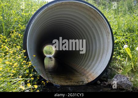 Tuyau de drainage perforé installé dans la zone rurale, regarder à travers le tuyau Banque D'Images