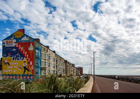 Sandylands Promenade, Heysham, Morecambe, Lancashire, Royaume-Uni. 9 juin 2021. Toujours caché derrière la peinture murale commandée par la publicité deco de Morecambe et peinte par Cobalt collective avec les artistes Erin Bradley-Scott et Kat Lowdon de la Cobalt collective mettant la touche finale à la peinture murale Shiftings Sands qui a été peinte sur le pignon d'une maison sur Sandylands Promenade la murale, qui est l'œuvre de l'artis et Morecambes Deco publique de Glasgow, rappelle les jours de gloire de Morecambes en tant que station balnéaire prospère crédit: PN News/Alamy Live News Banque D'Images