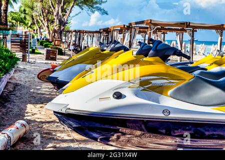 Motomarines garés sur la plage dans un complexe de la plage des Caraïbes tôt le matin Banque D'Images