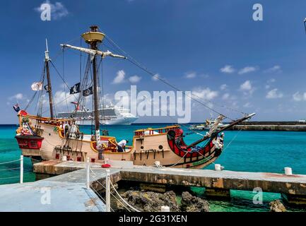 Bateau pirate amarré devant un bateau de croisière dans le port de George Town, îles Caïman Banque D'Images