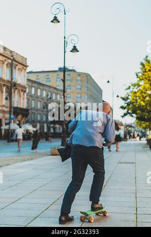 homme en voyage d'affaires, il fait du skateboard dans les rues de la ville Banque D'Images