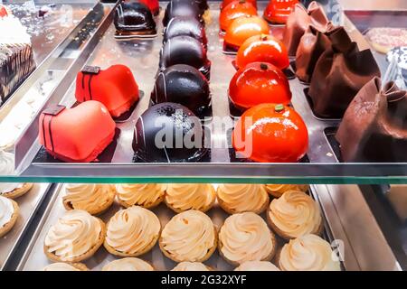 Bonbons savoureux dans la fenêtre de la boutique de confiserie. Pâtisseries fraîches, beignets, gâteaux Banque D'Images