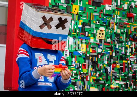 Moscou, Russie. 12 juin 2021 UN garçon avec une boîte aux couleurs du tricolore russe sur sa tête près de l'entrée du centre de divertissement Robostation au complexe d'exposition VDNH à Moscou pendant la célébration de la Fête de la Russie Banque D'Images