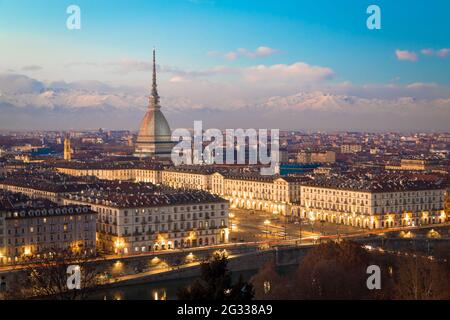 Turin, région du Piémont, Italie. Panorama depuis le Monte dei Cappuccini (colline du Cappuccini) au coucher du soleil avec les montagnes des Alpes et le monument Mole Antonelliana. Banque D'Images