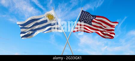 Drapeaux des États-Unis et de l'Uruguay agitant dans le vent sur les mâts de drapeaux contre le ciel avec des nuages le jour ensoleillé. Symbolisant la relation, le dialogue entre deux pays Banque D'Images