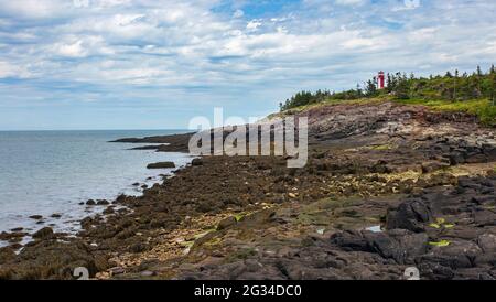 Phare de point Prim vu de la plage rocheuse en dessous pendant la marée basse. Situé près de Digby, Nouvelle-Écosse. Banque D'Images