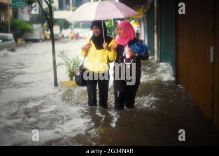 Jakarta, Indonésie. 9th février 2015. Des femmes marchant sur une passerelle inondée à Jakarta, après une pluie continue ont quitté le centre-ville de la capitale indonésienne inondé. Banque D'Images