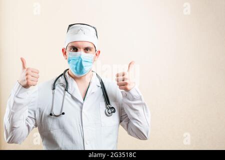 Médecin dans le masque et le chapeau, montrant le pouce vers le haut. Banque D'Images