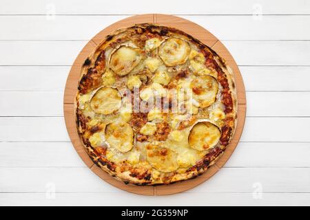 Pizza au fromage de chèvre sur une assiette en bois. Vue de dessus sur fond de tableau blanc Banque D'Images