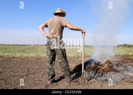 Un agriculteur brûle de l'herbe sèche dans son champ. Pollution de l'air. Banque D'Images