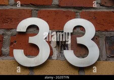 Un signe sur un mur avec le numéro trente-trois-33 Banque D'Images