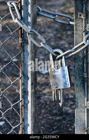 Photo d'un cadenas en métal sur une barrière et une clôture Banque D'Images