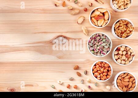 Noix, plan de dessus plat sur une table en bois avec un endroit pour le texte. Collations végétaliennes saines Banque D'Images