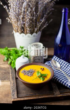 Soupe de potiron aux légumes avec lavande et persil. Lavande en cuisson, assaisonnement sous forme de coeur. Déjeuner sur une table en bois. Nourriture pour encore la vie Banque D'Images