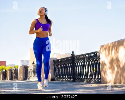Femme asiatique qui court dans le parc tôt le matin. Femme asiatique attrayante et en bonne santé. Concept de mode de vie sain. Banque D'Images