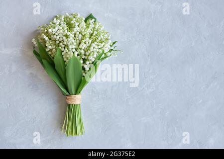 Bouquet de lys de la vallée sur fond bleu. Concept de carte postale. Copier la flèche. Banque D'Images
