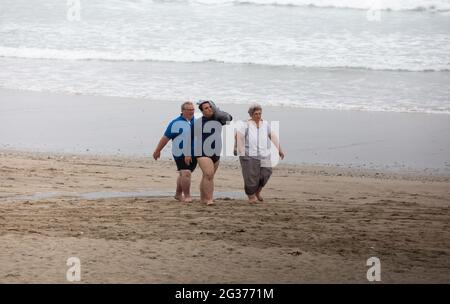 Portreath,Cornouailles,14 juin 2021, malgré avoir été couvert une promenade familiale le long de la plage pour leur exercice quotidien à marée basse dans Portreath,Cornouailles. La température était de 15C, ce qui est environ 10C plus frais que dans le nord du pays où Londres et Brighton ont des températures de 26C.Credit: Keith Larby/Alay Live News Banque D'Images