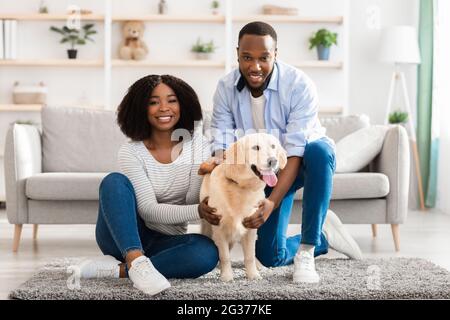 Couple noir passant du temps à la maison avec un chien Banque D'Images