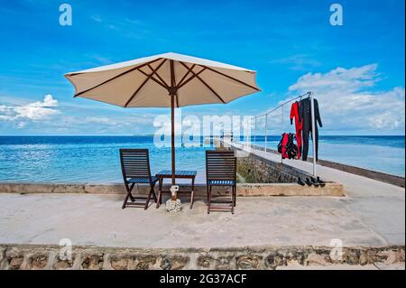 Jetée avec parasol, station de plongée Wakatobi, Sulawesi, Indonésie Banque D'Images