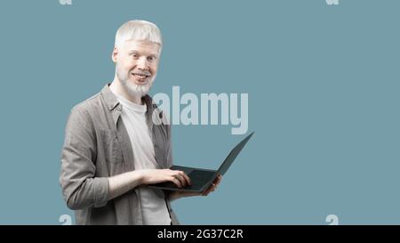 Travail à distance pour les étudiants. Un homme extraordinaire avec ordinateur portable sur fond bleu avec espace de copie Banque D'Images