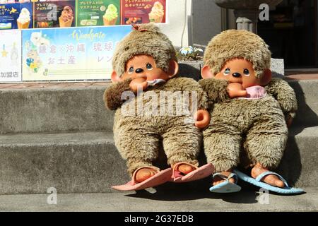 Deux grandes marionnettes Monchichi dans les escaliers devant une boutique de souvenirs, Kamakura, préfecture de Kanagawa, Japon Banque D'Images