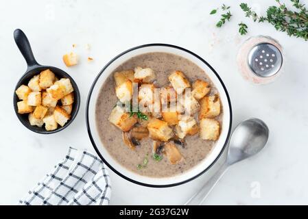 Soupe végétarienne à la crème de champignons avec croûtons sur fond de marbre blanc Banque D'Images