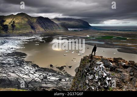 Langue du glacier, glacier, lac du glacier, glacier calant, icebergs, montagnes, ponceuse, homme sur le rocher, point de vue, plateau, Skaftafellsjoekull, Skaftafell Banque D'Images