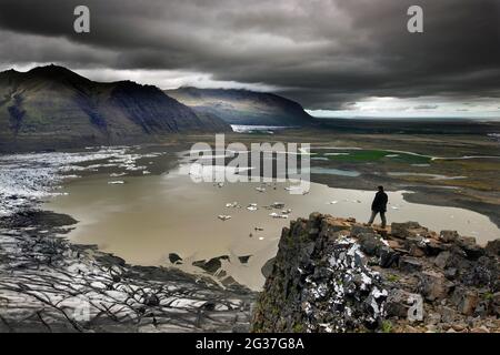 Langue du glacier, glacier, lac du glacier, glacier calant, icebergs, montagnes, ponceuse, homme sur le rocher, point de vue, plateau, Skaftafellsjoekull, Skaftafell Banque D'Images