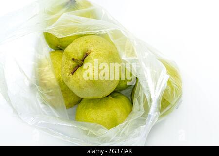 Vue de dessus quelques fruits de goyave thaïlandais dans un sac en plastique blanc du marché sur fond blanc. Banque D'Images