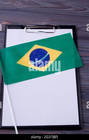 Drapeau brésilien de prise verticale sur le presse-papiers avec du papier vierge pour l'espace de copie. Banque D'Images