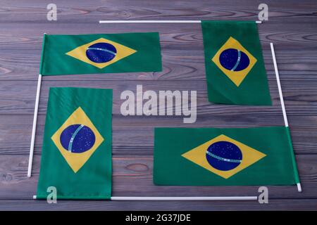 Composition de quatre drapeaux brésiliens sur fond de bois gris. Banque D'Images