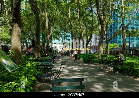 Personnes assises, marchant, dans l'ombre fraîche de Bryant Park, New York City, États-Unis. Banque D'Images