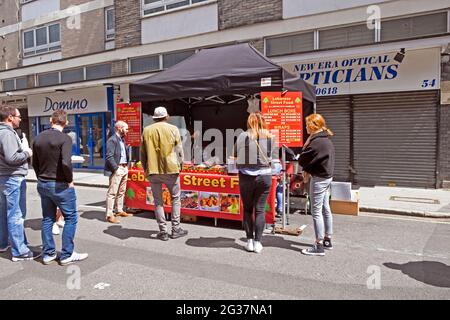 Les gens font la queue pour la nourriture de rue libanaise dans un stand dans Leather Lane Street Market London EC1 KATHY DEWITT Banque D'Images