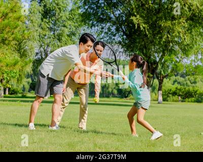 Bonne famille de trois joueurs de tennis dans le parc photo de haute qualité Banque D'Images