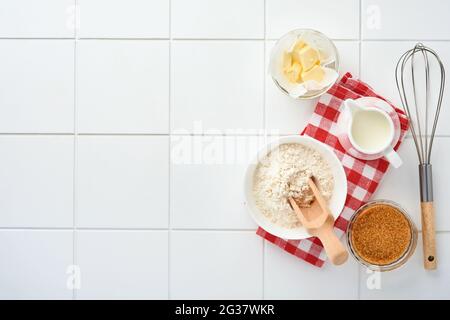 Préparation de pâte pour crêpes maison pour le petit déjeuner ou pour Maslenitsa. Ingrédients sur la table - farine de blé, oeufs, beurre, sucre, sel, lait. Réc Banque D'Images