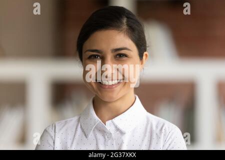 Photo de la tête d'une belle jeune femme d'affaires indienne souriante. Banque D'Images