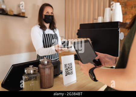 Client caucasien tenant une tablette, scannant un code qr, prenant la commande du propriétaire de l'entreprise Banque D'Images