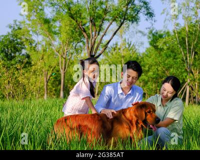 Bonne famille de trois et chien de compagnie jouant dans le parc photo de haute qualité