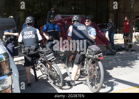 Austin, Texas, États-Unis. 14 juin 2021. La police de la ville d'Austin (TX) surveille pendant que les employés de la ville nettoient un grand camp de protestation des sans-abri du côté nord de l'hôtel de ville en milieu de matinée. La police a arrêté plusieurs sans-abri qui ont refusé de coopérer après plusieurs semaines d'avertissements et d'offres d'assistance. Crédit : Bob Daemmrich/Alay Live News Banque D'Images
