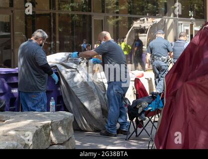 Austin, Texas, États-Unis. 14 juin 2021. La police de la ville d'Austin (TX) surveille pendant que les employés de la ville nettoient un grand camp de protestation des sans-abri du côté nord de l'hôtel de ville en milieu de matinée. La police a arrêté plusieurs sans-abri qui ont refusé de coopérer après plusieurs semaines d'avertissements et d'offres d'assistance. Crédit : Bob Daemmrich/ZUMA Wire/Alay Live News Banque D'Images