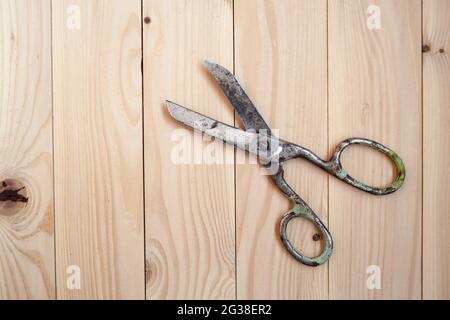 De grandes vieilles ciseaux sur un fond en bois clair. Banque D'Images