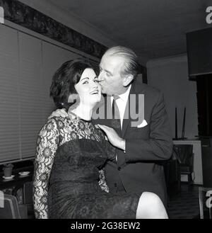 1965, historique, une jolie jeune femme aux cheveux sombres, la gagnante du concours de beauté « l'aide du Loch » qui reçoit un baiser ou un peck de félicitations sur la joue d'un gentilhomme bien habillé et adapté, Brucefield House, Écosse, Royaume-Uni. Banque D'Images